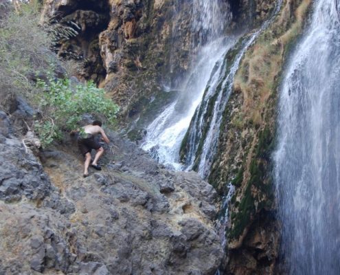 Steile Felsen mit Schlappen zu erklimmen, wie dieser abenteuerlustige Safari Gast, ist nicht nötig, um die Ngare Sero Wasserfälle im Lake Natron Gebiet zu erreichen